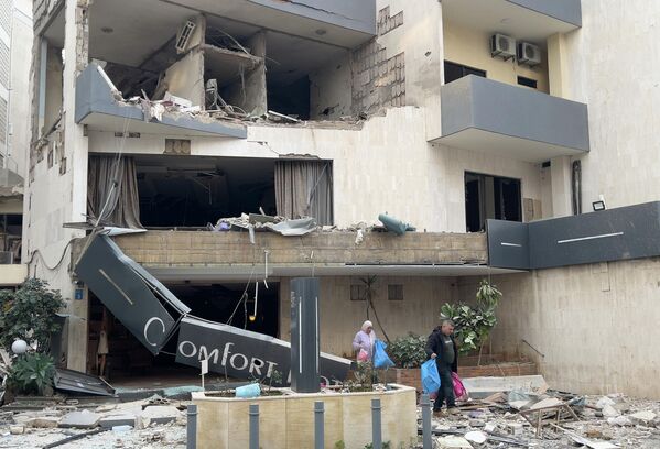 在贝鲁特以东的哈兹米耶，房客拖着行李离开一家被空袭损毁的酒店。 - 俄罗斯卫星通讯社