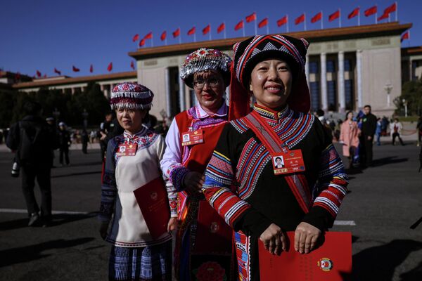 2026年3月11日，身着民族服饰的委员在中国人民政治协商会议闭幕会后离开北京人民大会堂。 - 俄罗斯卫星通讯社