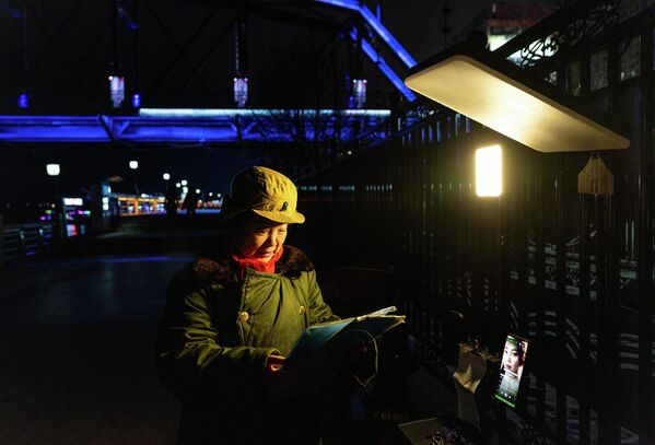 2026年1月14日，中国辽宁省丹东市，一名女子站在分隔朝鲜和中国的鸭绿江友谊桥附近。 - 俄罗斯卫星通讯社