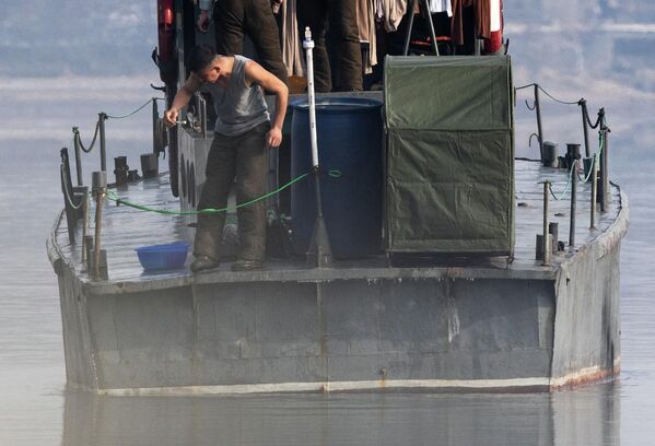 2026年1月15日，从中国辽宁省丹东市望去，一名朝鲜军人站在鸭绿江上的一艘巡逻艇船尾。 - 俄罗斯卫星通讯社