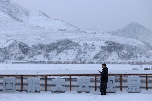 2026年1月15日，中国吉林省集安市，一名男子站在鸭绿江中国一侧的旅游观景台上，俯瞰朝鲜。 - 俄罗斯卫星通讯社