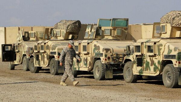 2011年11月7日，在伊拉克巴格达维多利亚基地，一名美国士兵走过即将运出伊拉克的军用装甲车 - 俄罗斯卫星通讯社