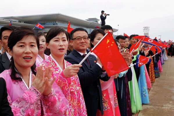 2026年4月9日星期四，人们在朝鲜平壤欢迎中国外长王毅抵达平壤国际机场。 - 俄罗斯卫星通讯社