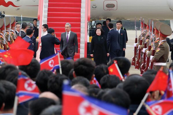 2026年4月9日星期四，中国外长王毅（中）抵达朝鲜平壤国际机场。图中右侧为朝鲜外相崔善姬。 - 俄罗斯卫星通讯社