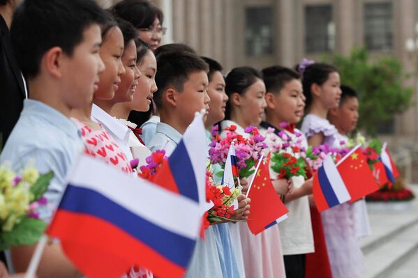 5月20日，在人民大会堂为俄罗斯总统普京举行的欢迎仪式前，手持俄罗斯和中国国旗的儿童。 - 俄罗斯卫星通讯社