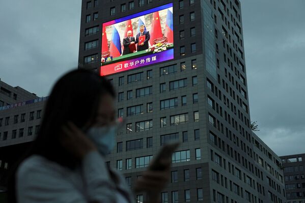 2026年5月20日,中国北京,一名行人驻足于巨幅屏幕前,屏幕上正播放着中国国家主席习近平与俄罗斯总统弗拉基米尔·普京在人民大会堂签署仪式上的新闻画面。 2026年5月20日,中国北京,一名行人驻足于巨幅屏幕前,屏幕上正播放着中国国家主席习近平与俄罗斯总统弗拉基米尔·普京在人民大会堂签署仪式上的新闻画面。 - 俄罗斯卫星通讯社