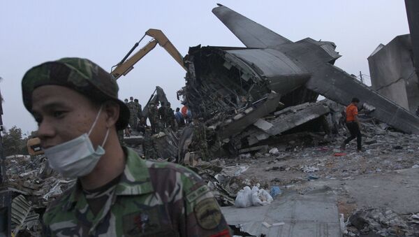 An Indonesian soldier stands near the tail section of a military C-130 transport plane which crashed yesterday into a residential area in Medan, North Sumatra, Indonesia July 1, 2015 - 俄羅斯衛星通訊社