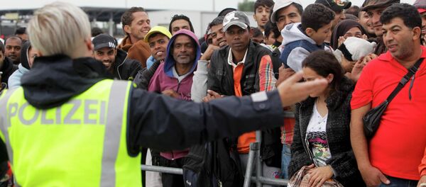 An Austrian police officer speaks to migrants at the border cross with Hungary in the town of Nickelsdorf, Austria An Austrian police officer speaks to migrants at the border cross with Hungary in the town of Nickelsdorf, Austria - 俄罗斯卫星通讯社