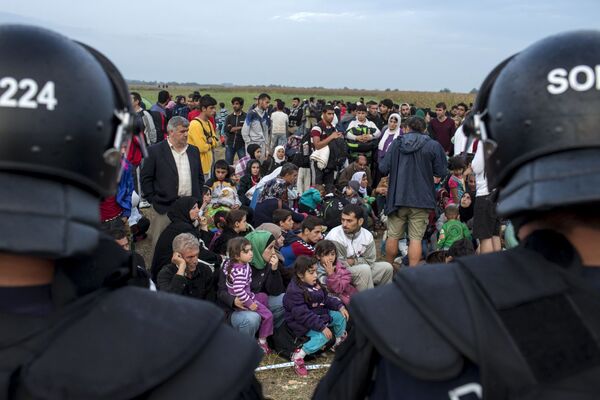 敘利亞移民從塞爾維亞越過塞爾維亞-匈牙利邊境後，坐在被警方包圍的場地上 - 俄羅斯衛星通訊社