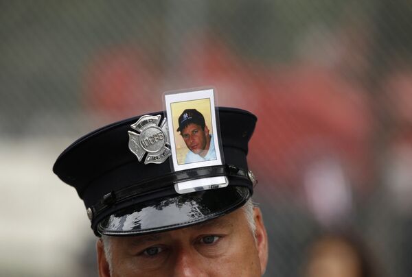 消防员将一张“9•11”遇难者照片别在军帽上 - 俄罗斯卫星通讯社