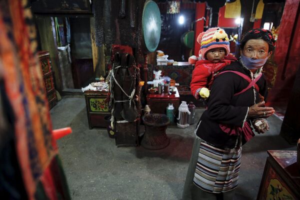带着孩子的藏族妇女在拉萨的庙宇中 - 俄罗斯卫星通讯社