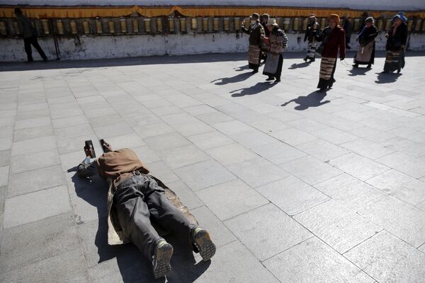 西藏男子在拉萨的布达拉宫前入神地祈祷 - 俄罗斯卫星通讯社