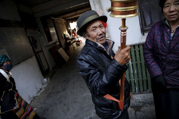 在拉薩的老城區，一名藏族男子在轉動祈禱輪 - 俄羅斯衛星通訊社