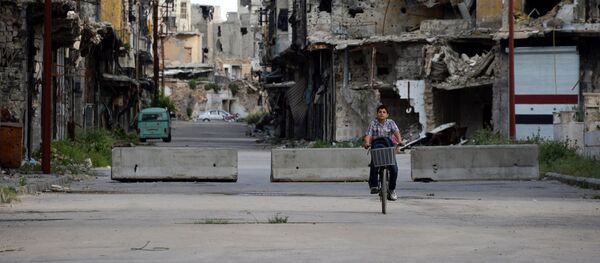 Мальчик на велосипеде на одной из улиц в Хомсе Мальчик на велосипеде на одной из улиц в Хомсе - 俄罗斯卫星通讯社