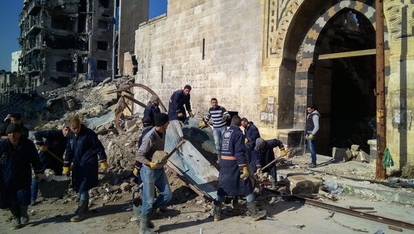 Residents clear up streets in the Al Naziriya neighborhood in the Syrian city of Aleppo. - 俄罗斯卫星通讯社