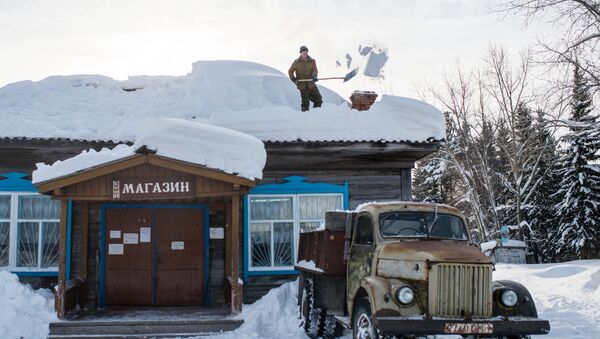 一名男子在清掃博布羅夫卡村商店房頂上的積雪 - 俄羅斯衛星通訊社