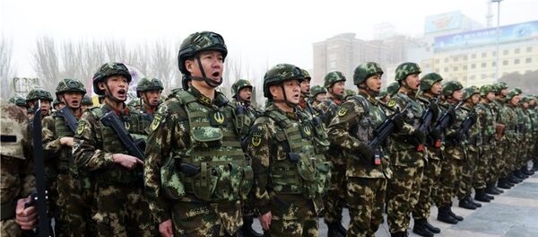 新疆喀什地区“反恐维稳誓师大会”现场,千余军、警、民兵等方队集结待命。 - 俄罗斯卫星通讯社