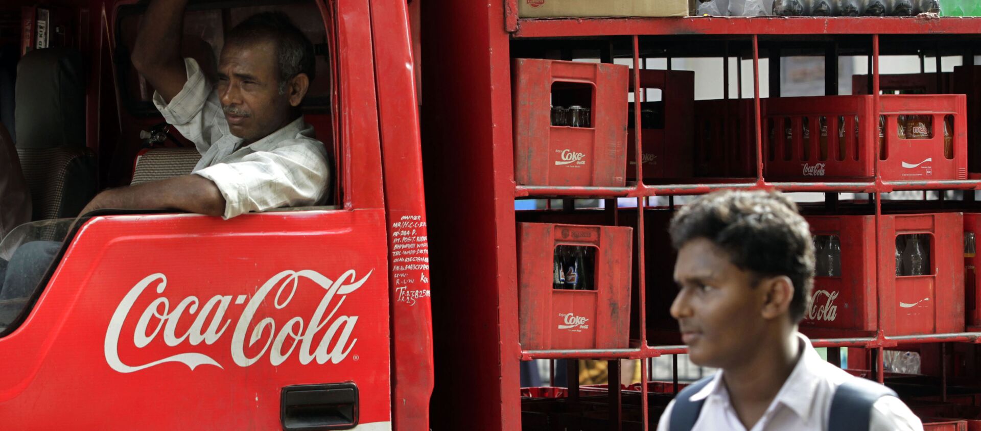 A man walks past a truck that distributes Coca Cola in Mumbai, India - 俄羅斯衛星通訊社, 1920, 18.12.2020