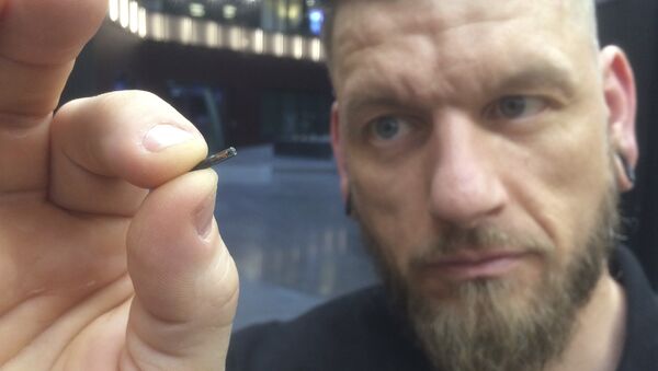 Jowan Osterlund from Biohax Sweden, holds a small microchip implant, similar to those implanted into workers at the Epicenter digital innovation business centre - 俄罗斯卫星通讯社