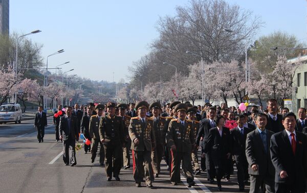 街上的人們都穿著講究，他們在指定地點集合，其中有軍人、學生、黨員幹部、工人...... - 俄羅斯衛星通訊社