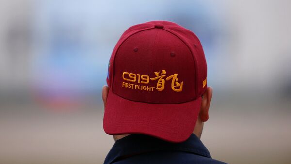 Мужчина в кепке надписью, посвященной самолету C919, в аэропорту Пудун - 俄羅斯衛星通訊社