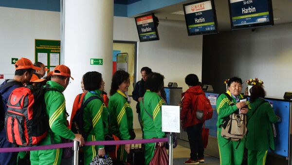 Пассажиры у стойки регистрации китайской авиакомпания Sichuan Airlines на рейс до Харбин в международном аэропорту Владивостока - 俄罗斯卫星通讯社