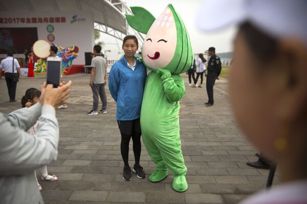 北京龍舟賽期間，一個女孩與粽子吉祥物合影。 - 俄羅斯衛星通訊社