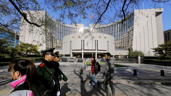 People walk past the headquarters of the People's Bank of China in Beijing - 俄羅斯衛星通訊社