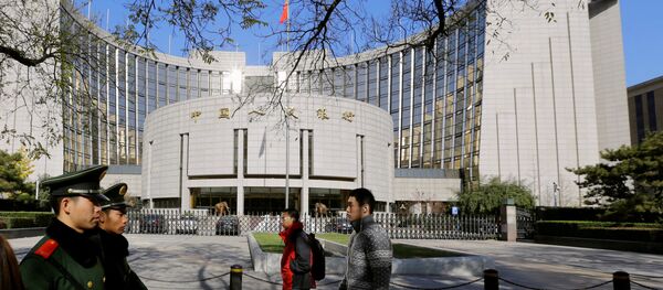 People walk past the headquarters of the People's Bank of China in Beijing - 俄罗斯卫星通讯社