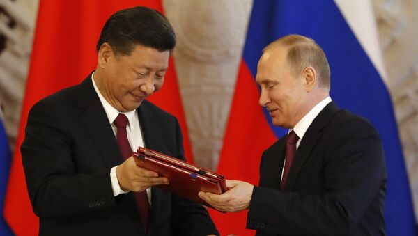 Russian President Vladimir Putin (R) exchanges documents with his Chinese counterpart Xi Jinping during a signing ceremony - 俄罗斯卫星通讯社
