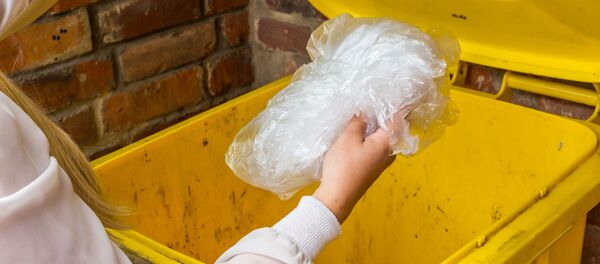 Женщина выбрасывает пакет в мусорный контейнер - 俄羅斯衛星通訊社