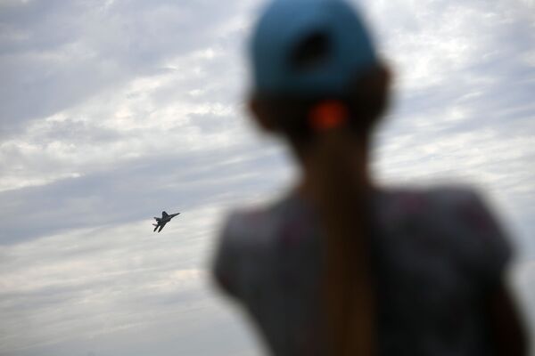 一個女孩正在觀看其中一架參展飛機進行飛行訓練。 - 俄羅斯衛星通訊社
