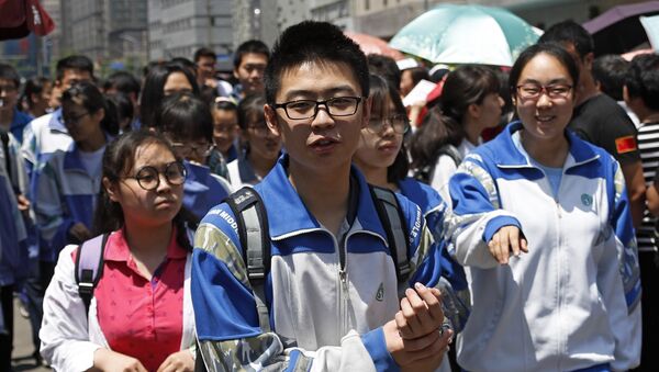 A student holds his hand as he and others exit a school after finishing their first subject exam during the first day of the annual Gao Kao or national college entrance exam - 俄羅斯衛星通訊社