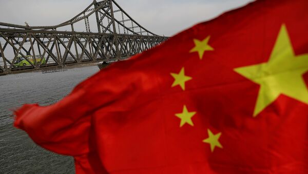 A Chinese flag is seen in front of the Friendship bridge over the Yalu River - 俄羅斯衛星通訊社