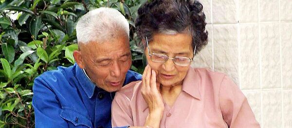 An elderly Chinese couple reads a tourist brochure - 俄罗斯卫星通讯社