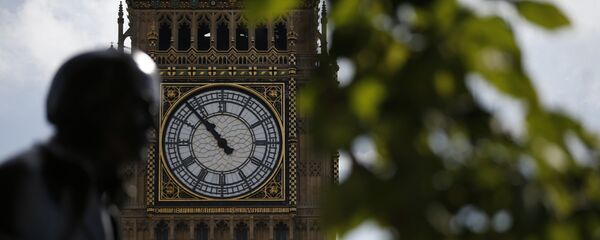 The statue of former British Prime Minister David Lloyd George is silhouetted against the Queen Elizabeth Tower which holds the bell known as 'Big Ben' in London - 俄罗斯卫星通讯社