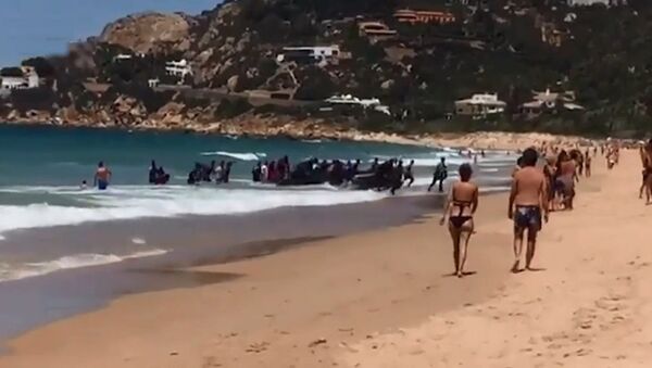 度假人群在西班牙海滩围观移民船到岸 - 俄罗斯卫星通讯社