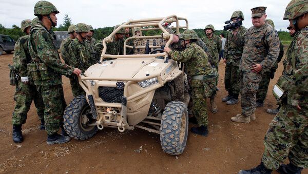 Силы самообороны Японии разглядывают американский мотовездеход во время военных учений с США на острове Хоккайдо - 俄罗斯卫星通讯社