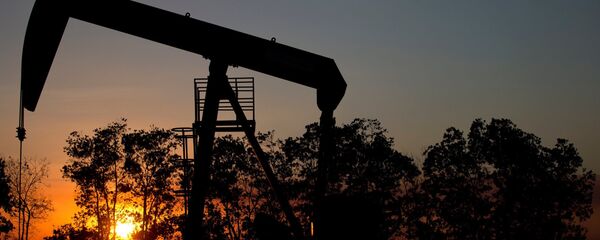 The sun sets behind an oil well in a field near El Tigre, Venezuela - 俄罗斯卫星通讯社
