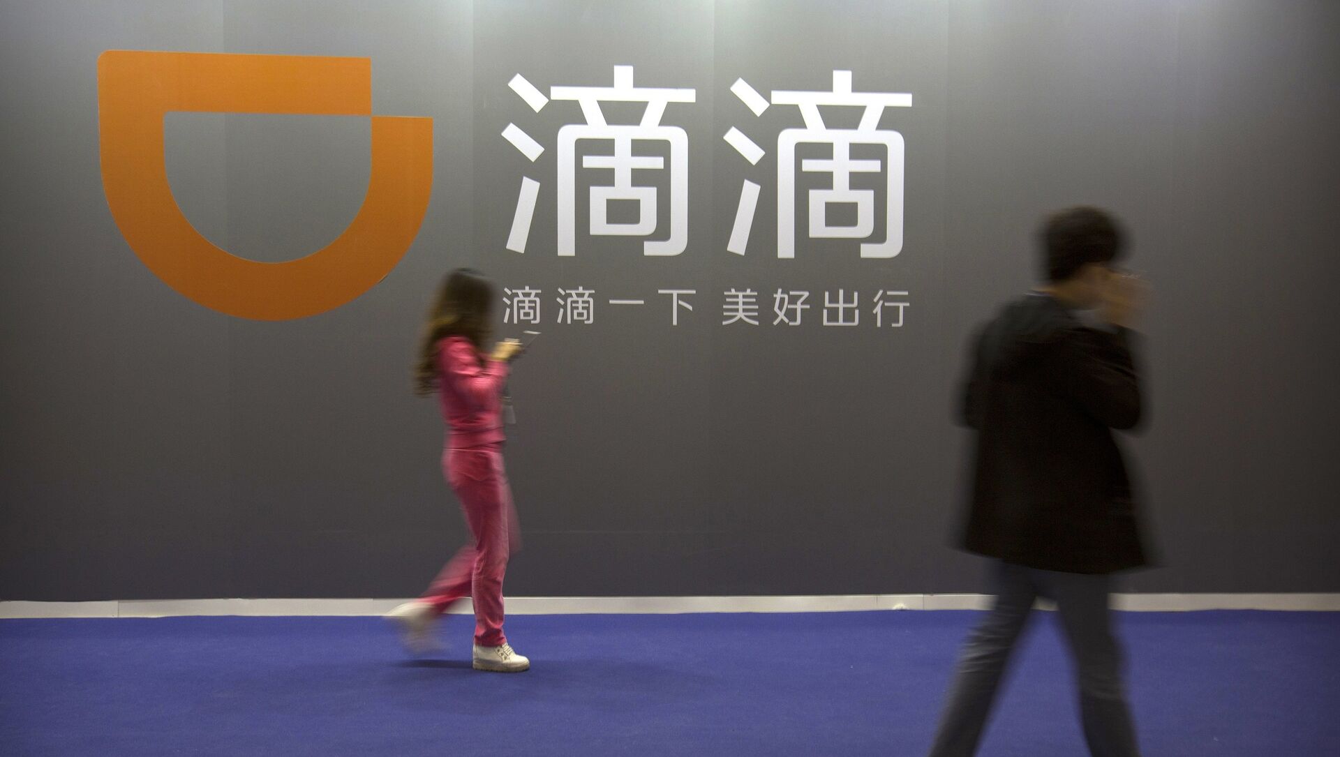 Visitors walk past a sign for Chinese ride-hailing service Didi Chuxing at the Global Mobile Internet Conference (GMIC) in Beijing - 俄罗斯卫星通讯社, 1920, 05.07.2021