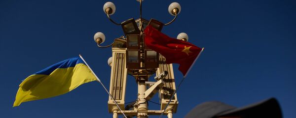 A man walks beneath Ukrainian and Chinese flags on Tiananmen Square in Beijing - 俄羅斯衛星通訊社