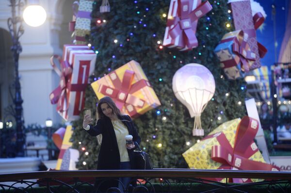 一位女性顾客与商场的新年枞树合影。 - 俄罗斯卫星通讯社