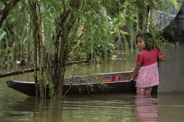 馬來西亞遇洪水襲擊，圖為一名小女孩站在一艘小船旁 - 俄羅斯衛星通訊社