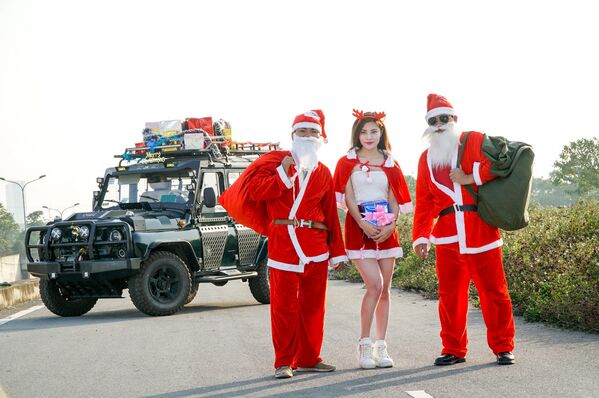 越南姑娘装扮成圣诞老人在俄产越野车旁照片 - 俄罗斯卫星通讯社