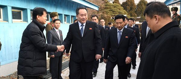 Head of North Korean delegation Ri Son Gwon shakes hands with South Korean official as he crosses the concrete border to attend their meeting at the truce village of Panmunjom - 俄羅斯衛星通訊社