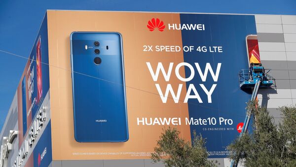 A crew hangs a Huawei advertising banner on the side of the Las Vegas Convention Center - 俄羅斯衛星通訊社