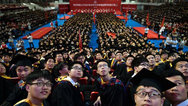 Students from the Huazhong University of Science and Technology taking part in their graduation ceremony in a sports stadium in Wuhan - 俄罗斯卫星通讯社