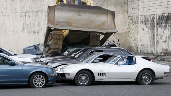 A bulldozer runs over a fleet of used luxury and sports cars during condemnation ceremony as part of the 116th anniversary celebration of the Bureau of Customs in Manila, Philippines - 俄羅斯衛星通訊社