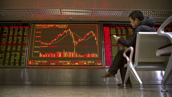 A Chinese investor uses his smartphone as he monitors stock prices at a brokerage house in Beijing - 俄羅斯衛星通訊社