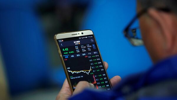 An investor checks stock information on a mobile phone at a brokerage house in Shanghai - 俄罗斯卫星通讯社